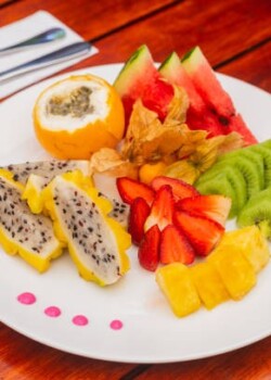 Healthy fruit breakfast on the hotel table based on strawberries, pineapple, dragon fruit, granadilla